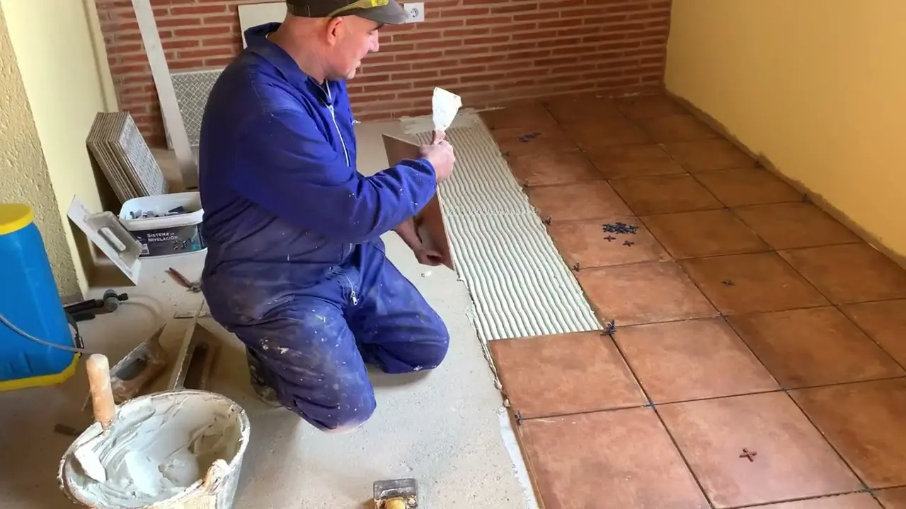 Solador colocando baldosa de barro cocido sobre cemento cola — Colocación de suelos