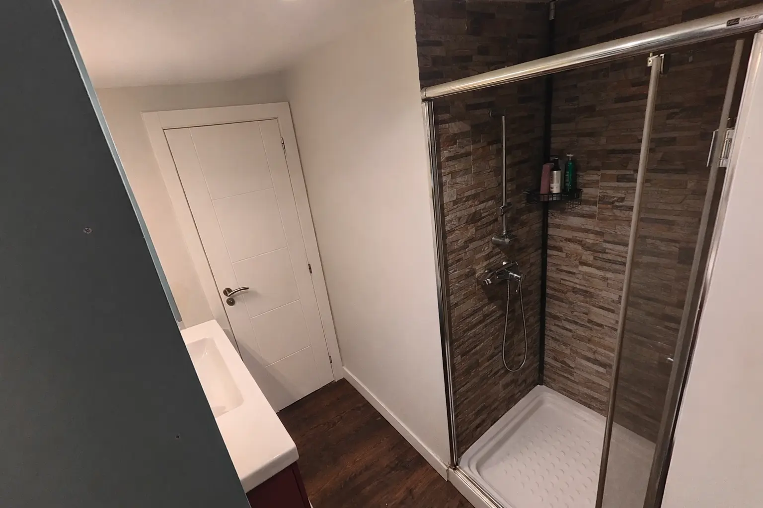 resultado reforma de baño interior en Irún — ducha de obra y extractor en baño sin ventana