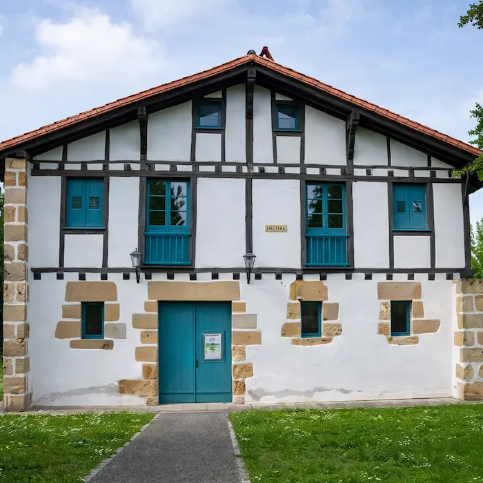  équipe Reformas Ordoñez sur un chantier de rénovation intégrale : équipe bilingue en réunion de chantier autour d'un plan de maison, murs en pierre visibles en arrière-plan