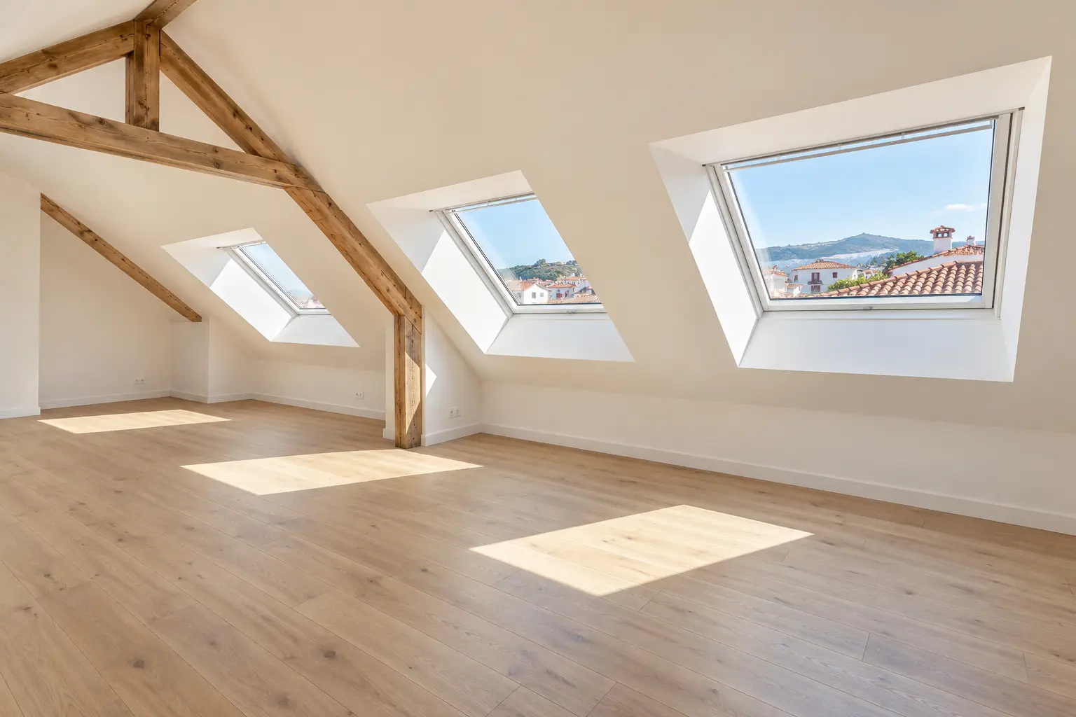 Chantier d'aménagement de combles à Saint-Jean-de-Luz montrant l'habillage des rampants sous toiture en plaques de plâtre standard et des cloisons en placo vert hydrofuge délimitant une future salle de bain.