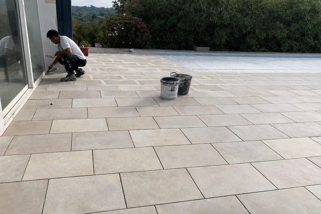 carreleur vérifiant la pente d'une terrasse avant carrelage à Biarritz